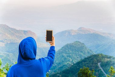Akıllı telefon alarak fotoğraf DOI Angkhang dağ, Chiangmai, Tayland üst kısmındaki kullanılarak hipster blogger.