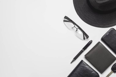 Kopya alanı ile beyaz arka plan üzerinde düz yatıyordu üstten görünüm erkekler aksesuarları. Şapka, para cepler, glassess, araba anahtarı, kalem, beyaz arka plan üzerinde günlük defter.