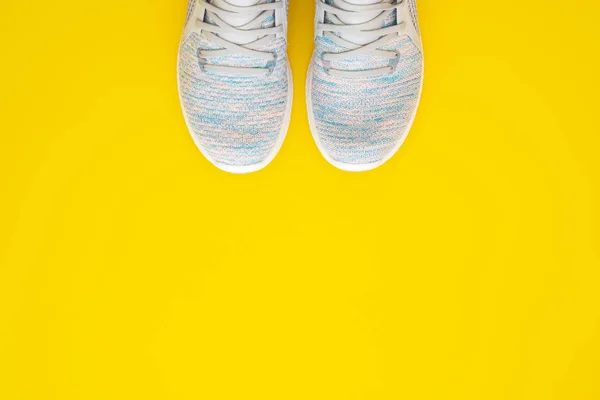 Пара жіночих спортивних кросівок на жовтому тлі. Вид зверху відьма — стокове фото