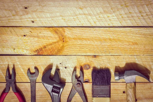 Conjunto oxidado sucio de herramientas de mano de construcción en respaldo de madera de grano — Foto de Stock