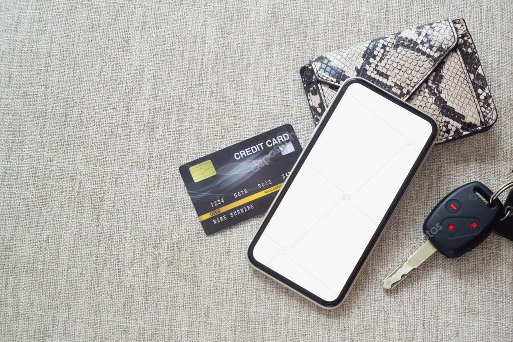 Mockup blank screen mobile phone for online payment and Car rental online application background concept. Mock up white screen cellphone with credit card, car key, wallet, top view, flat lay