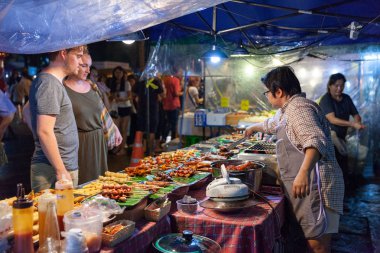 Chiang Mai, Tayland - 27 Ağustos: Çift geleneksel Tay street, Cumartesi gece pazarı (Street yürüyüş) üzerinde 27 Ağustos 2016 Chiang Mai, Tayland satın gıda.