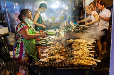 Chiang Mai, Tayland - 27 Ağustos: Gıda satıcı üzerinde 27 Ağustos 2016 Chiang Mai, Tayland Cumartesi gece pazarı (Street yürüyüş) balık pişiriyor.