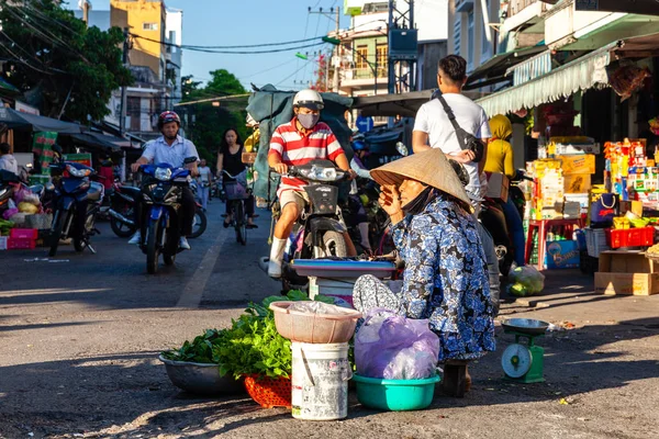 Nha Trang, Vietnam - Ağustos 06: 06 Ağustos 2018 yılında Nha Trang, Vietnam sokak piyasada yeşilliklerle kadın kıdemli satıyor.