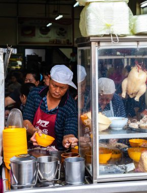 Adam Ipoh bir gıda mahkemesinde müşteriler için tavuk çorbası kadar hizmet vermektedir