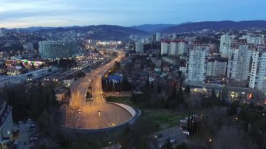 Güzel dron görünümü şehir, dağlar ve katlama Kurortnyy Prospekt otoyol alacakaranlıkta, Sochi, Rusya Federasyonu