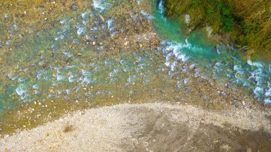 Islak kayalar ve çakıl shore ile dağ nehir rapids tepeden dron görünümü