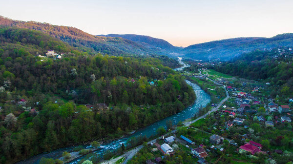 Drone view of mountains and Plastunka village in the valley of the Sochi river in spring evening, Sochi, Russia