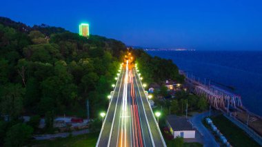 Drone görünümü ışıklı Matsesta Viyadüğü, dağın ile yoğun orman ve deniz alacakaranlıkta, Sochi, Rusya Federasyonu