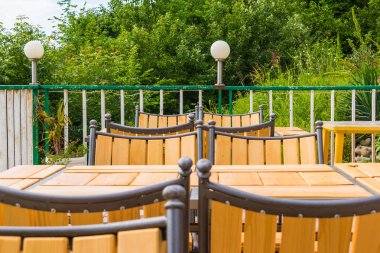 Ahşap masa ve sandalyeler yaz günü içinde yemyeşil bitki örtüsü arka plan üzerinde Teras