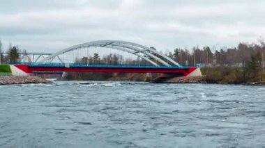 Yakınlaştırmalı hızlandırılmış video. Trafikli Vuoksi Nehri Köprüsü manzarası ve bulutlu sonbahar gününde Vuoksi Nehri akışı, Losevo, Leningrad Oblastı, Rusya