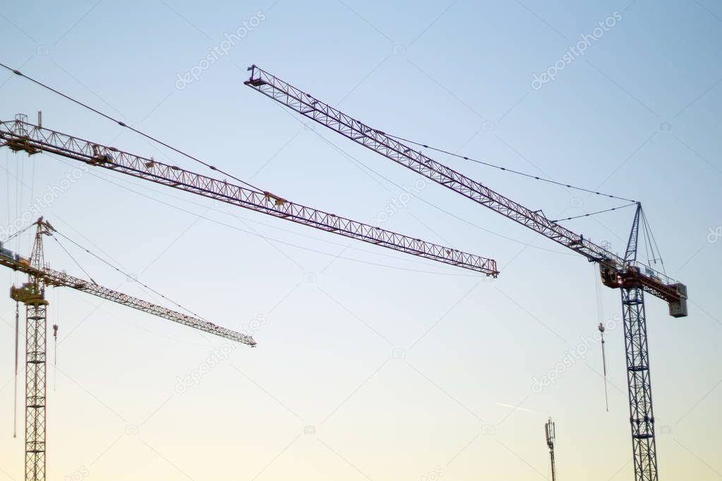Yellow construction cranes at sunset