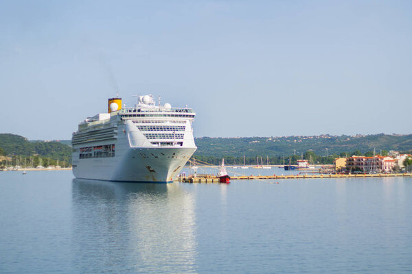 Big white overseas cruise ship in port. Wide angle image with surroundings.