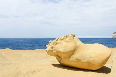 Denizin arka planında büyük kum taşı Bulutlu gökyüzü