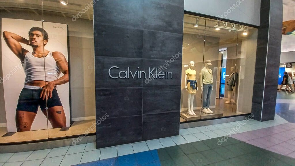 Toronto, ON, Canada - August 30, 2025: The Calvin Klein logo is mounted on a gray tile wall inside a retail store.