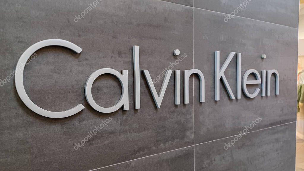 Toronto, ON, Canada - August 30, 2025: The Calvin Klein logo is mounted on a gray tile wall inside a retail store.