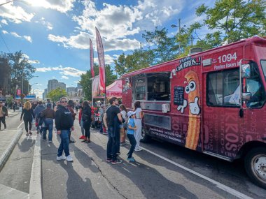 Toronto, ON, Kanada 9 Eylül 2024: İnsanlar güneşli bir öğleden sonra yemek standı, müzik ve etkinlikleriyle Kingsway Street Festivali 'nin tadını çıkarıyor..