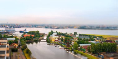 Oyuncak nehir manzarası. Nehir, deniz, deniz istasyonu ve sanayi binaları. Tilt-shift etkisi, Saint Petersburg, Rusya