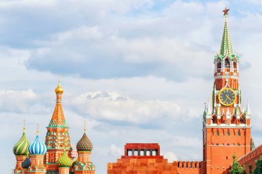 Kızıl Meydan, Moskova, Rusya. Kremlin 'in Spasskaya Kulesi' nde saat, Lenin 'in mozolesi ve St. Basil Katedrali. Parlak yaz manzarası, bulutlu gökyüzünde kopya alanı ile seyrek çerçeve kompozisyonu
