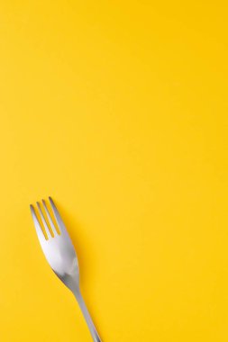 Sarı üzerine paslanmaz çatal. Gıda tema şablonu ve arkaplan