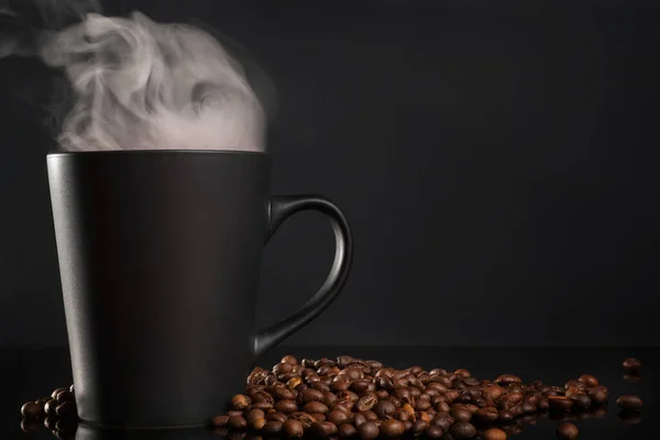 Schwarze Tasse Kaffee Mit Dampf Und Kaffeebohnen Auf Schwarzem Tisch — Stockfoto