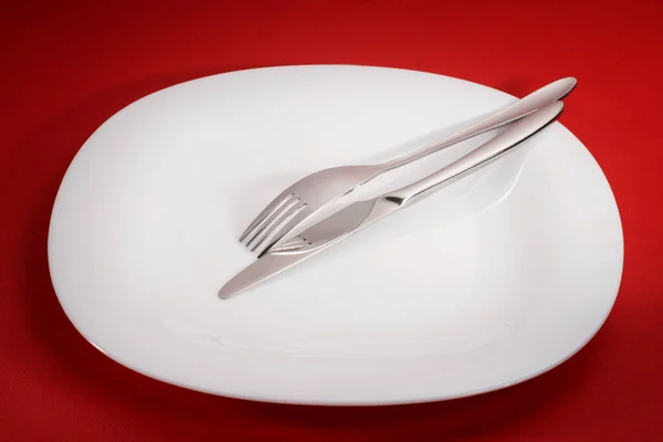 Λευκό Άδειο Τετράγωνο Πιάτο Πιρούνι Και Μαχαίρι Στο Κόκκινο Τραπέζι — Φωτογραφία Αρχείου