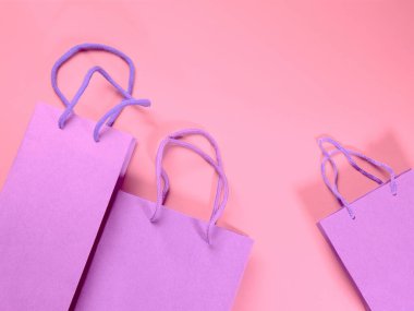 Pembe karton arka planda duran şenlikli hediye paketleri. Kopya alanı ile soyut alışveriş teması şablonu