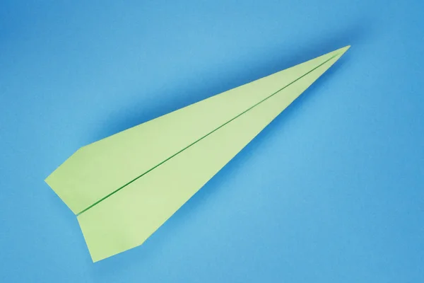 蓝色硬纸板背景图上的绿纸平面 — 图库照片