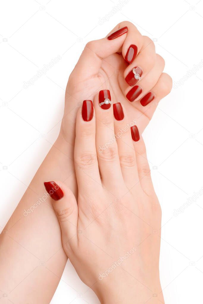 Woman hands with red art nail polish and rhinestones. Isolated on white, clipping path included