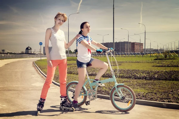 Две Юные Подруги Одна Велосипеде Другая Ролере Летний Спорт Досуг — стоковое фото