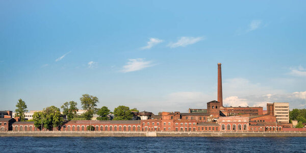 Old stationery factory at Neva river quay panoramic view. Red brick historic industrial building. Saint Petersburg, Russia