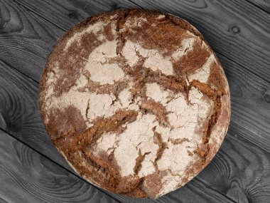 Yuvarlak taze pişmiş rulo kahverengi ekmek. Ahşap masadan yoksun üst görünüm