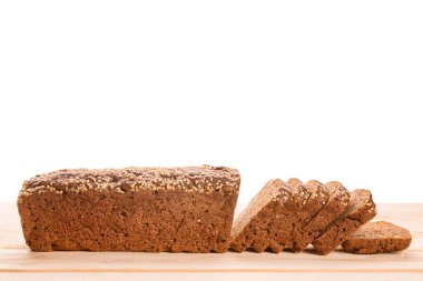 Ahşap masa manzarasında dilimlenmiş uzun çavdar ekmeği. Ekmeğe odaklan. Beyazda izole edilmiş