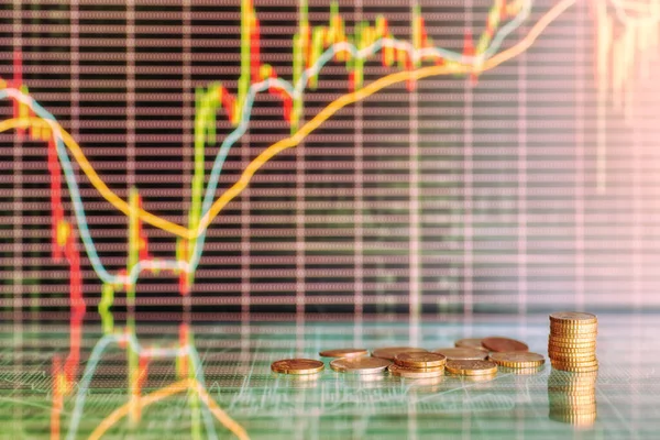 Money and stock market graphs. Coins against futuristic display with candles diagrams