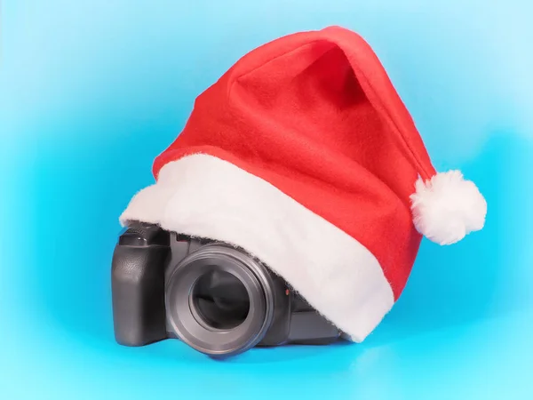 红色圣诞礼帽下的照相相机 蓝色的 — 图库照片