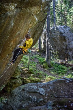 Kaya tırmanışçısı zorlu bir uçuruma tırmanıyor. Aşırı spor tırmanışı. Özgürlük, risk, mücadele, başarı. Spor ve aktif yaşam konsepti. 