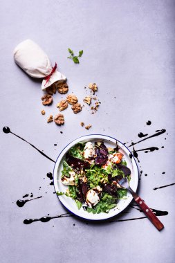 Salad of beetroot, arugula, cheese and walnut. Top view, copy space, flat lay. Organic clean healthy diet concept.