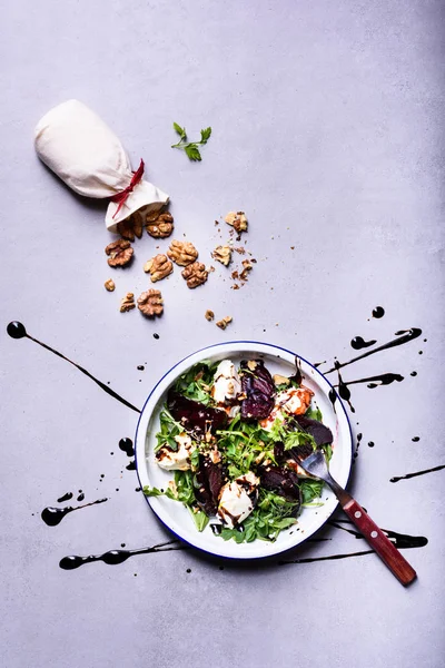 Salad of beetroot, arugula, cheese and walnut. Top view, copy space, flat lay. Organic clean healthy diet concept.