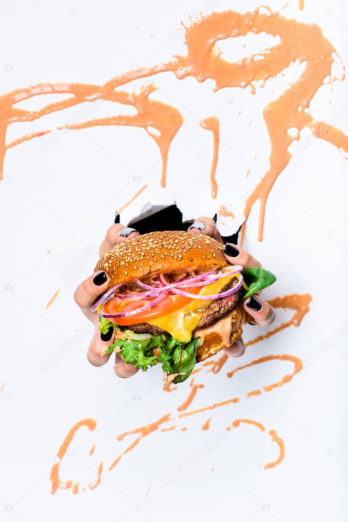 Burger with beef cutlet in persons hands. Close up, Fast food. White background.