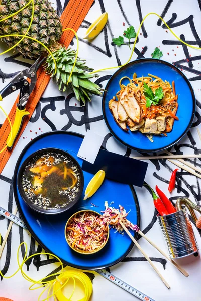 Assorted asian dinner food set. Chicken teriyaki with noodles and miso soup. Dishes of thai cuisine. Top view.