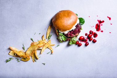 Sığır eti, kızılcık reçeli ve krem peynirli burger. Biberiyeli patates kızartması. Üst görünüm, kopyalama alanı.
