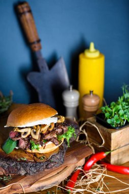 Tahta tahtada et ve mantarlı ev yapımı hamburger. Kapat..