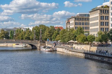 Almanya 31 Ağustos 2025. Köprü, gezinti tekneleri ve nehir gezinti güvertesiyle Spree 'nin manzarası. İnsanlar gezer ve güneşin tadını çıkarır..