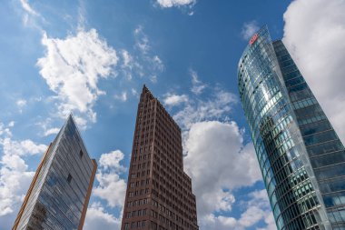 Potsdamer Platz Kuleleri. Potsdamer Platz 'da üç çarpıcı gökdelen gökyüzüne yükseliyor. Cam ve tuğla ön cepheleri etkileyici bir şekilde tezat oluşturuyor..