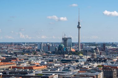 Berlin Katedrali ve TV Kulesi 'nin vinçler ve çatılarla çevrili yakın görüntüsü. Sahne, Berlin 'in gelenek ve modernlik karışımını vurguluyor.
