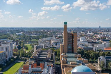 Kulturforum kompleksinin yüksek tuğla kulesi Berlin 'in yeşil parklar ve açık gökyüzü tarafından çerçevelenmiş şehir manzarası üzerinde yükseliyor..
