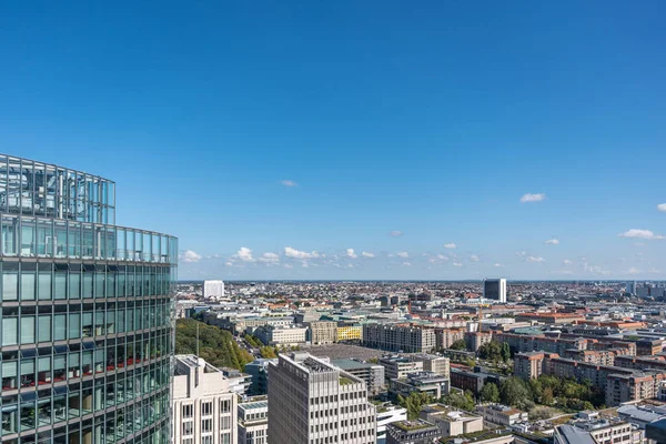 Berlin gökyüzü açık mavi gökyüzünün altında modern kuleler ve tarihi çatılarla ufuk çizgisine kadar uzanıyor..