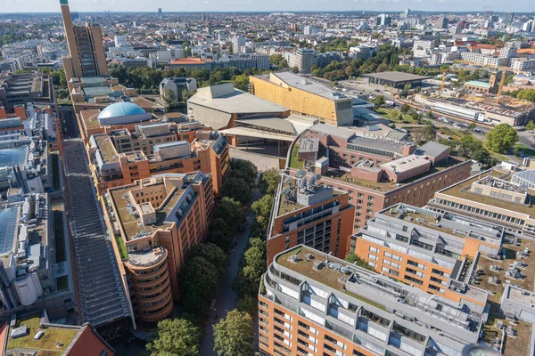 Berlin 'in Kulturforum bölgesinin hava perspektifi, açık güneş ışığında Filarmoni, modern bloklar ve yapraklı caddeleri gösteriyor.