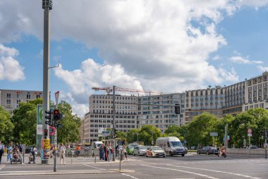 Almanya 8 Eylül 2025. Yoğun trafik ve büyük bir kavşakta insanlar var. Arka planda cam cepheli modern binalar.