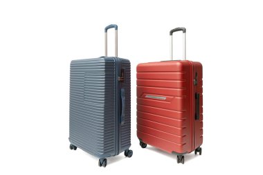 Mavi ve kırmızı dönen bavullar sergilenmek üzere açılı. Sağlam tekerlekler ve teleskopik saplar tasarımı tamamlar. Seyahat valizi beyaz arka planda izole edildi.